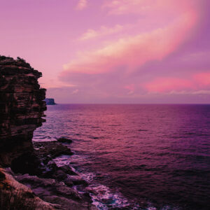 Dramatic pink sunset over Gap Bluff, Watsons Bay in Sydney, with vibrant colors lighting up the ocean horizon.