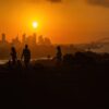 Sunset over the Sydney Skyline at Dudley Page Reserve. Silhouettes of people against the Sydney Skyline.