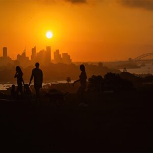 Sunset over the Sydney Skyline at Dudley Page Reserve. Silhouettes of people against the Sydney Skyline.
