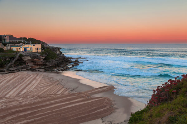 Coastal wall art print of Tamarama Beach with a vibrant orange glow capturing the serene beauty of the Sydney shoreline.