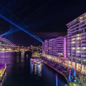 Acrylic print of Bennelong Apartments with a vivid purple glow, part of the Vivid Sydney collection, ideal for elegant home and office decor.