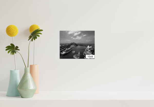 Black and white photograph of the iconic Sydney Harbour skyline, featuring the Sydney Opera House and Harbour Bridge against a timeless backdrop. Perfect as wall decor, this art print captures the city's architectural beauty and urban landscape in a classic monochrome style.