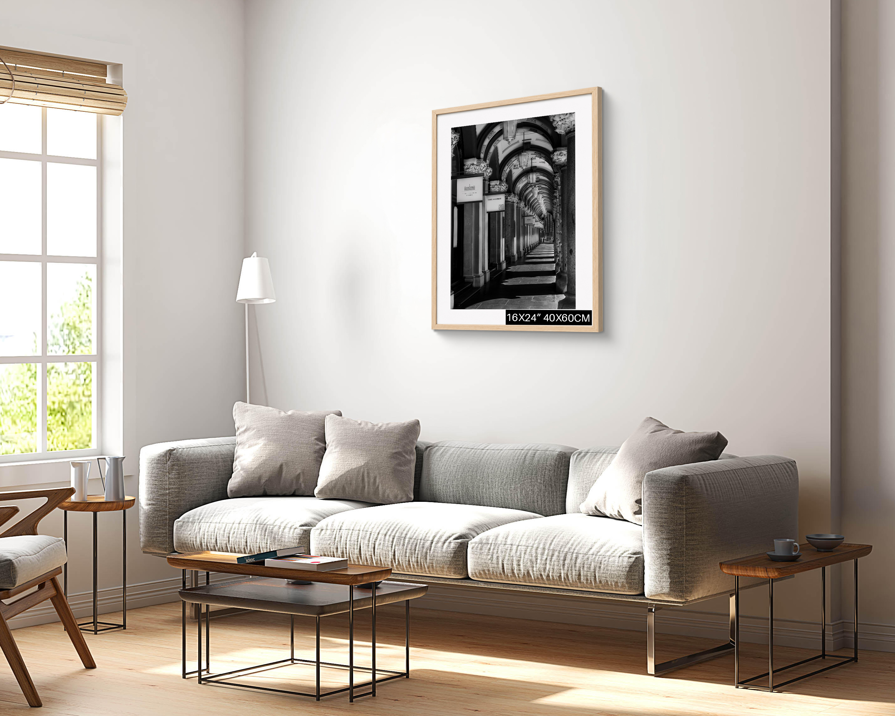 The Colonnades Sydney black and white architectural photograph displayed as a 16 × 24 inch framed wall art print in a natural timber frame above a grey sofa in a bright contemporary living room.