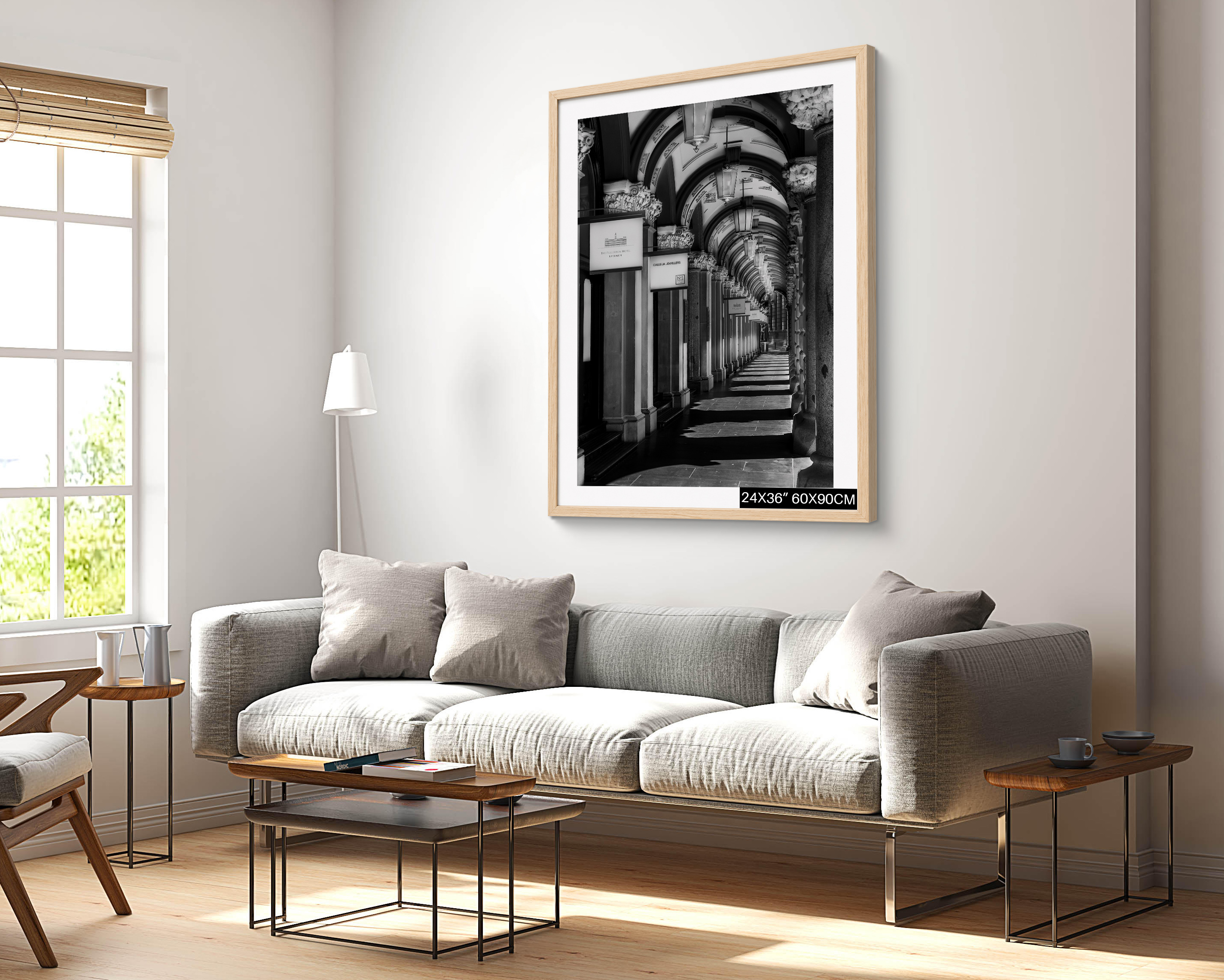 The Colonnades Martin Place Sydney black and white photograph featuring repeating arches and ornate columns, presented as a 24 × 36 inch framed wall art print above a grey sofa in a bright living room.