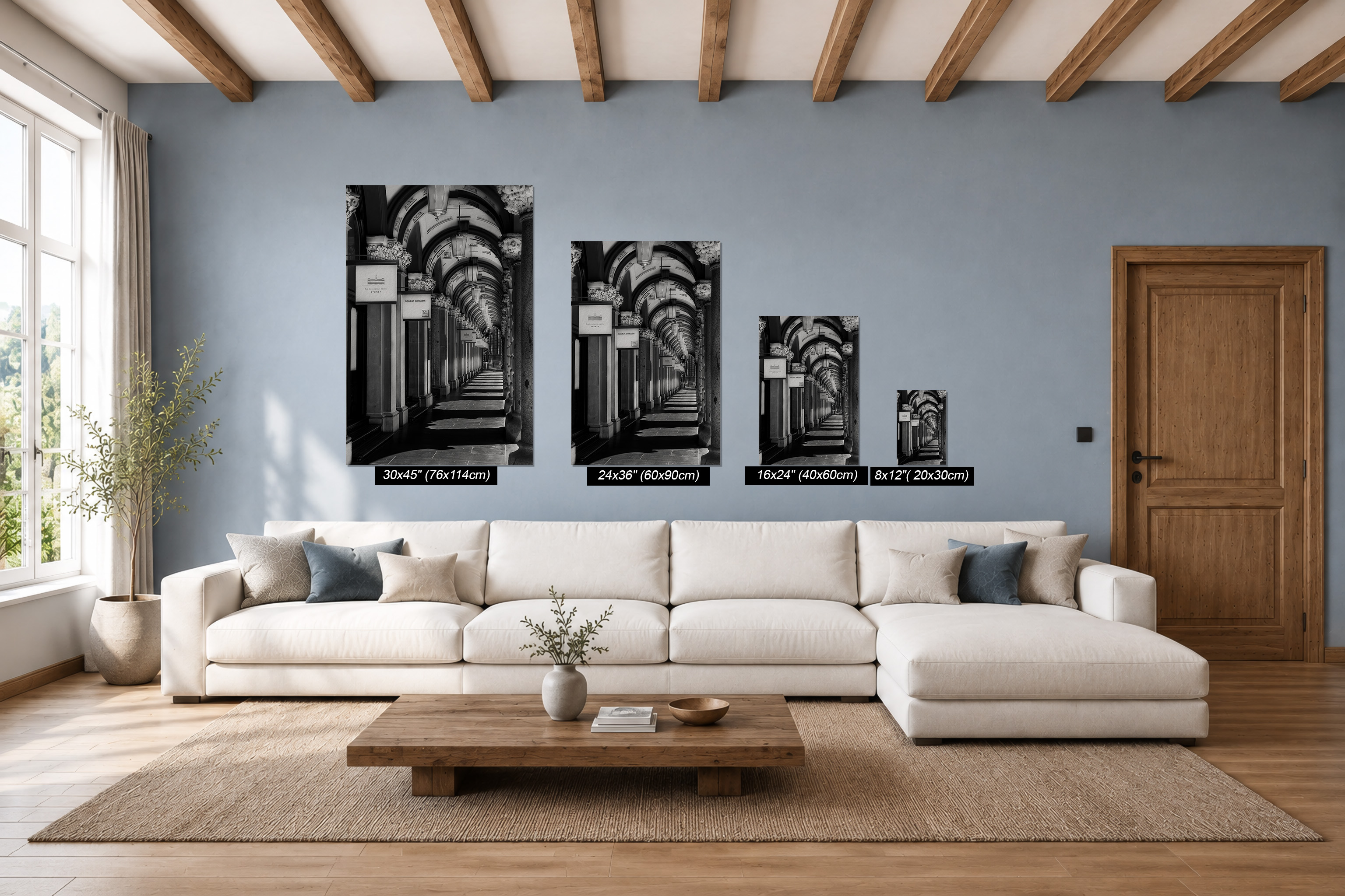 The Colonnades Martin Place Sydney black and white architectural photography shown as four vertical fine art paper prints in different sizes above a white sofa in a modern living room with exposed timber beams.