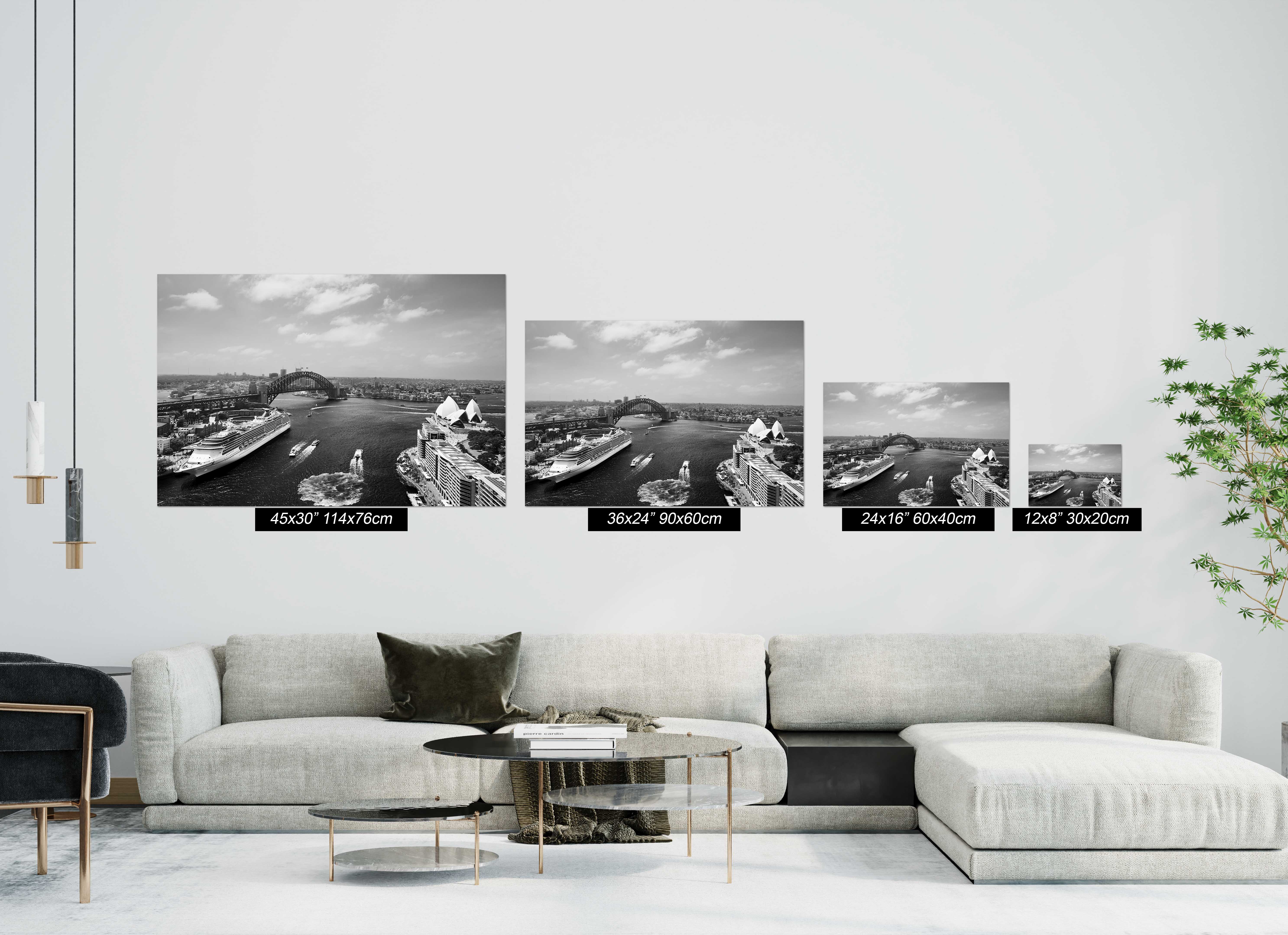 Sydney Harbour black and white photography print shown in Enhanced Matte Paper sizes from 12 × 8 to 45 × 30 inches above a modern sofa.